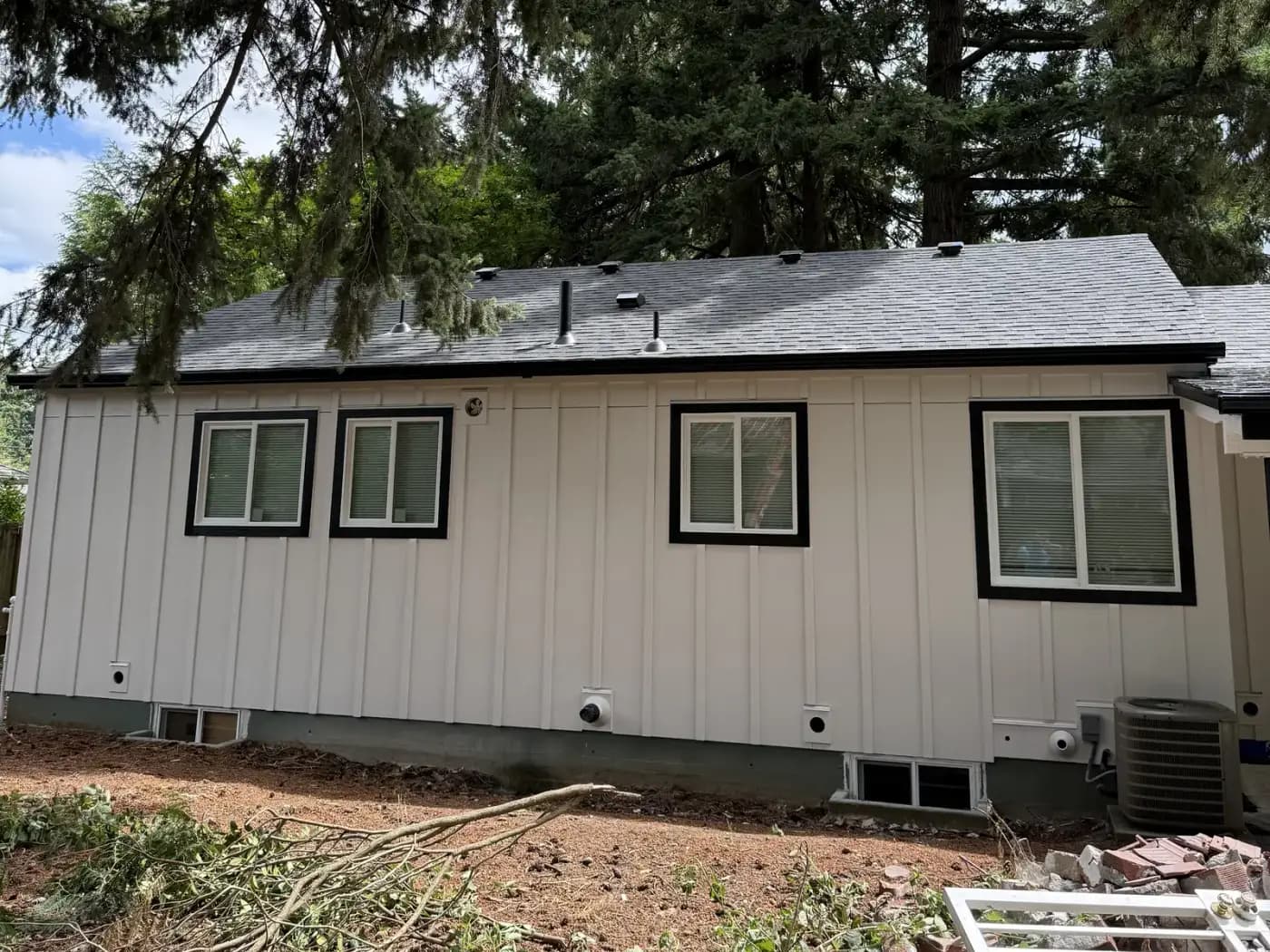 Freshly painted white board-and-batten exterior with black window trim — a recent HANDY TEAM PRO project